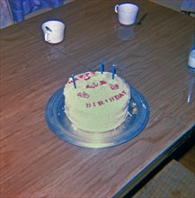 Birthday cake with three candles and a clown on top circa 1969.