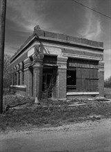 Black and white photo of abandoned bank in the ghost town of Truscott Texas circa 1990s .