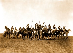 Edward S. Curtis Native American Indians - Brulé Indians, many wearing war bonnets, on horseback circa 1907.