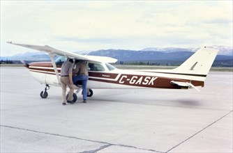Man stepping into a Cessna Skyhawk II airplane circa 1983.