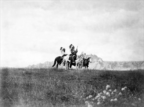 Edward S. Curits Native American Indians - Three Sioux Indians of horseback on plains with rock formation in background circa 1905.