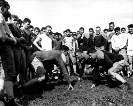 Football training has begun at constabulary headquarters at Bamberg, Germany. Practicing blocking are, Left to Right, Pfc, Bernard Clark of Sleepeye, Minn., and Pfc. Dang Davison circa 8/20/1946.