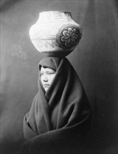 Edward S. Curits Native American Indians - En Al Leih, Indian woman, with decorated clay pot on head circa 1903.