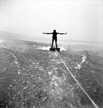 Man skiing behind a boat on a board circa 1930s.