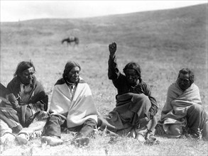 Edward S. Curtis Native American Indians - Four Atsina men, one with arm and fist raised skyward, one holding a wing circa 1908.