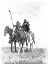 Edward S. Curtis Native American Indians - Two Atsina chiefs on horseback, one with feathered staff and one with a coup stick circa 1908.