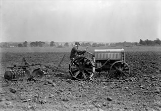 Farmer driving Ford Tractor in field circa 1917.