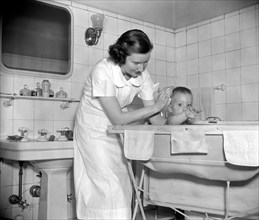 A woman giving a baby its bath circa 1937.