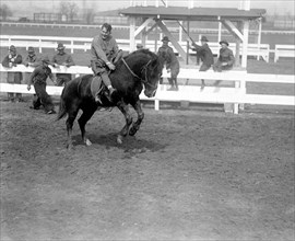 Historical Wild West Horse show given by soldiers, man riding bucking horse circa 1919 .