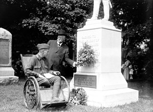 Wounded soldier in wheelchair visits monument at Alrington National Cemetery circa 1919 .