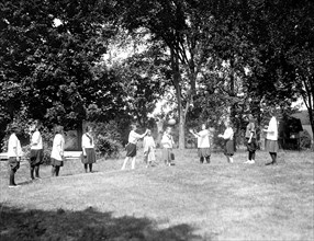 Young girls playing a game outdoors at a YWCA camp (Young Woman's Christian Association) circa 1919.
