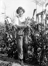 Girl Scout harvesting corn circa 1919 .