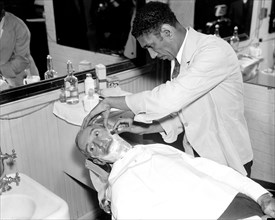 Senator Guy Howard of  Minnesota receiving a shave at the Senate barber shop circa 1936.