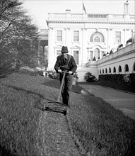 White House gardener at the Executive Mansion, is mowing the lawn today circa 1937.