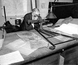 Geological Survey. Washington, D.C., March 13. Albert Pike using a stereoscope on a pair of photographs to bring out the relief and locate objects for a map circa 1937.