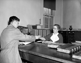 Marriage License Clerk helping a customer circa 1937.