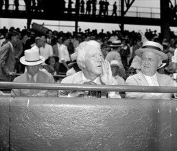 Kenesaw Mountain Landis, High Commissioner of baseball, assumes his characteristic pose for the cameramen as he views the 1937 all-star game in the Capitol, 7/7/37.