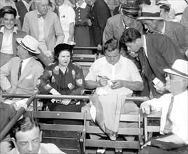 1937 - Babe Ruth at All-Star game signing a baseball for a fan .