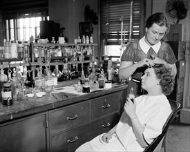 Testing cosmetics for the government. Washington D.C. July 10- Mrs. R. Goodman, is shown sitting with Mrs. C.R. West applying dye for the hair, some dyes contain lead and the poison in the dye may lea...