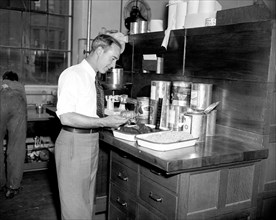 Government worker at Treasury Department testing food circa 1937 .