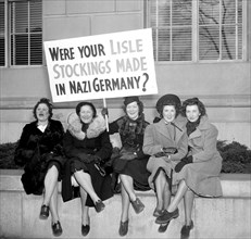 Women protesting for silk hose, holding picket sign - anti-nazi sign  circa 1938.