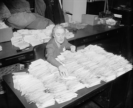 January 28, 1938 - Miss Margaret Lehand, Personal Secretary to President Roosevelt, is shown opening some of the 30,000 letters with donated dimes to the infantile paralysis foundation to arrive in th...