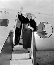 Apple blossom queen, Adelaide Moffett Brooks waves as she arrives at Washington Airport circa 1938.