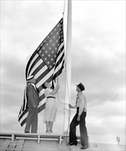 Representative Nan Honeyman, of Oregon, lowers the flag at Capitol circa 1938.