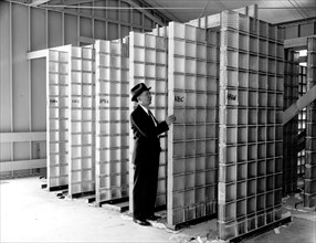 Worker at the Bureau of Standards making extensive tests of hollow glass building blocks circa 1938 .