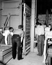 Workers at the National Bureau of Standards testing the strength of  glass panels circa 1938 .
