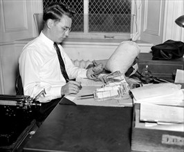 An agent cecking over confiscated counterfeit currency at the Secret Service Division of the Treasury Department circa 1938.