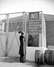 A policeman whose beat is on Washington's waterfront seems puzzled over how he is going to enforce the restrictions in the sign, especially as applied to seagulls circa 1939.