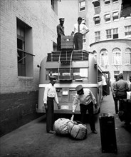 Workers at Greyhound bus station loading luggage circa 1937.