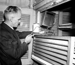 Weather employee at typical weather station with a temperature chart circa 1936.