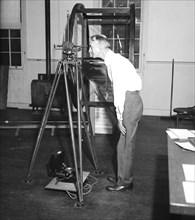 Dr. W.F. Wallis looking through a Magnemometer circa 1936.
