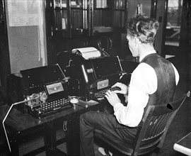 Worker operating a new radio teletypewriter service which allows for instantaneous transmission of written records without the aid of wires, has been perfected by the experts of the Bureau of Air Comm...