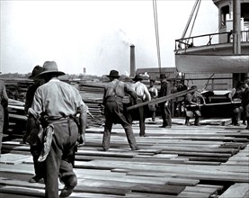 Men and boys loading lumber onto the steam freighter Reliance at the waterfront in Deseronto, Ontario. This vessel was built by the Rathbun Company in 1881 circa 1907.