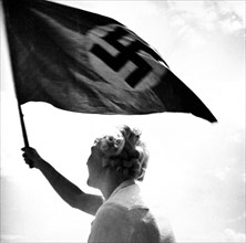Woman waving Nazi flag circa late 1930s or early 1940s.