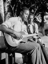 African American men playing guitar and singing; Gabriel Brown and Rochelle French, Eatonville, Florida circa June 1935.