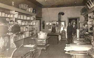 interior of a store selling kitchen equipment including pots, pans, plungers and 'Perfection' and 'Champion' kitchen ranges circa 1911.