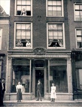 People standing outside of a building on Langestraat in Alkmaar Netherlands circa 1900 (long street) .