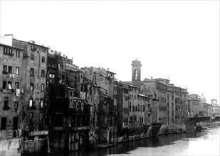 View of buildings alongside a river in Florence Italy circa late 1930s .