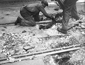 Worker helping with Streetcar track removal circa 1935.