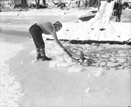 Female Skater helping man in ice water circa 1934.