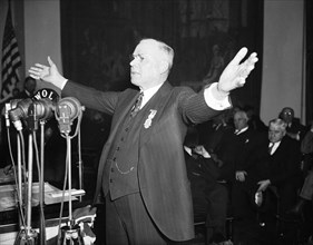 William Green standing and talking in front of microphones, gesticulating as he speaks passionately circa 1936.