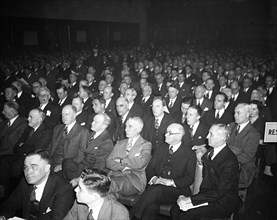 Men in a crowd listening intently circa 1935.