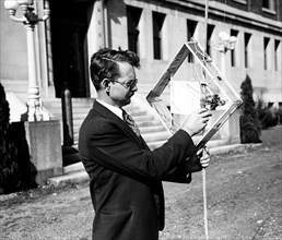 Dr. L.F. Curtiss, of the U.S. Bureau of Standards, is shown here with part of the equipment he uses in experiments using radio to gather meteorological data at great altitudes circa 10/17/1935.