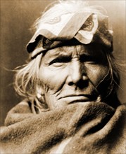 Edward S. Curtis Native American Indians - Si Wa Wata Wa, bust portrait, facing front, wearing blanket and handkerchief headband circa 1903.