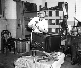 Trades: Man repairing chair circa 1936.