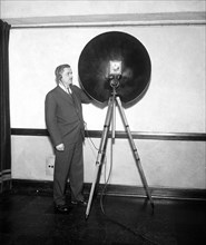 Man with an NBC parabolic dish microphone used for recording distance sounds  circa 1931.